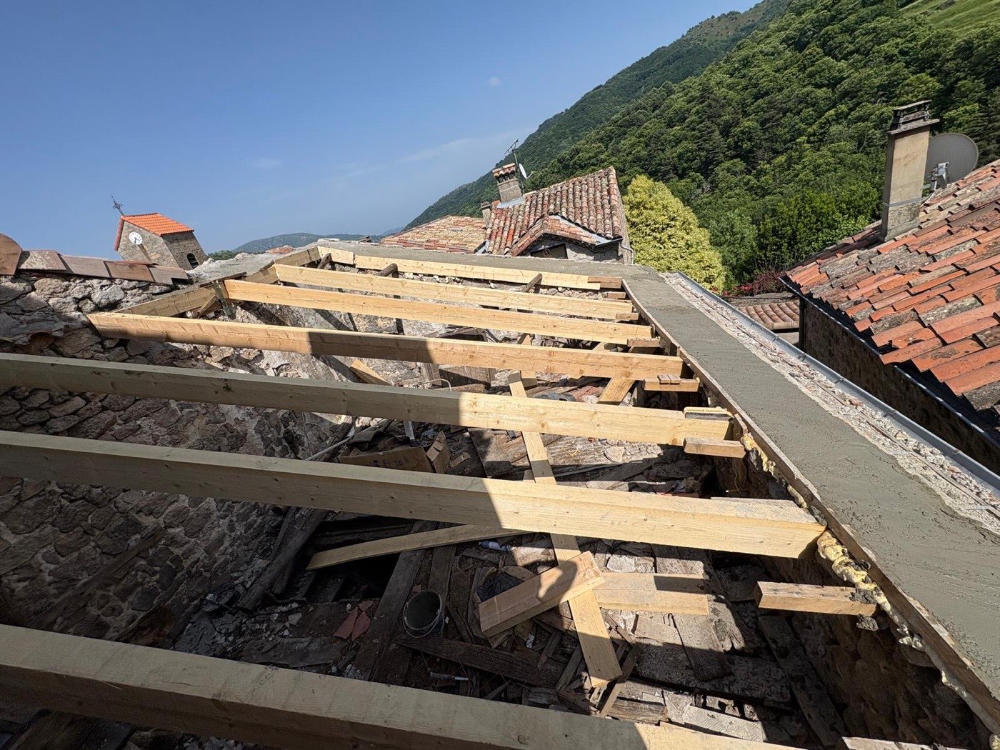 Charpente neuve en pin posée sur des murs en pierre lors d’une rénovation de toiture en Ardèche