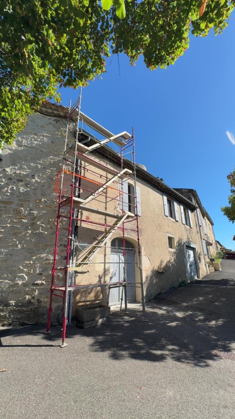 Échafaudage installé sur une façade en pierre pour un ravalement en Ardèche