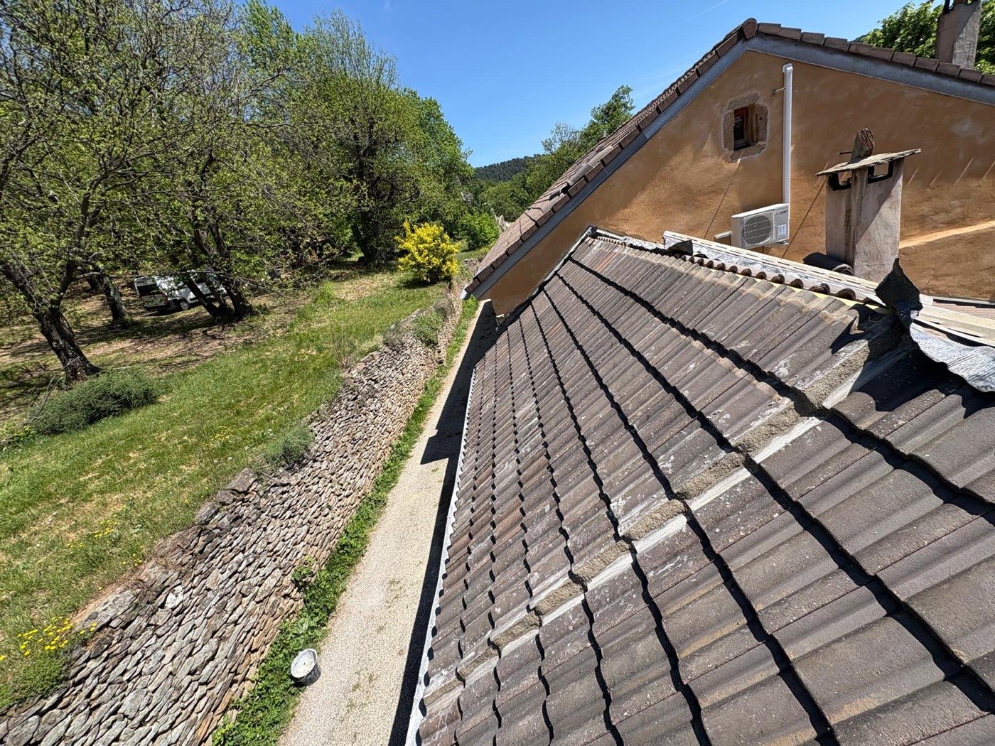 Couverture en tuile rénovée sur une maison en Ardèche, mur en pierre sèche